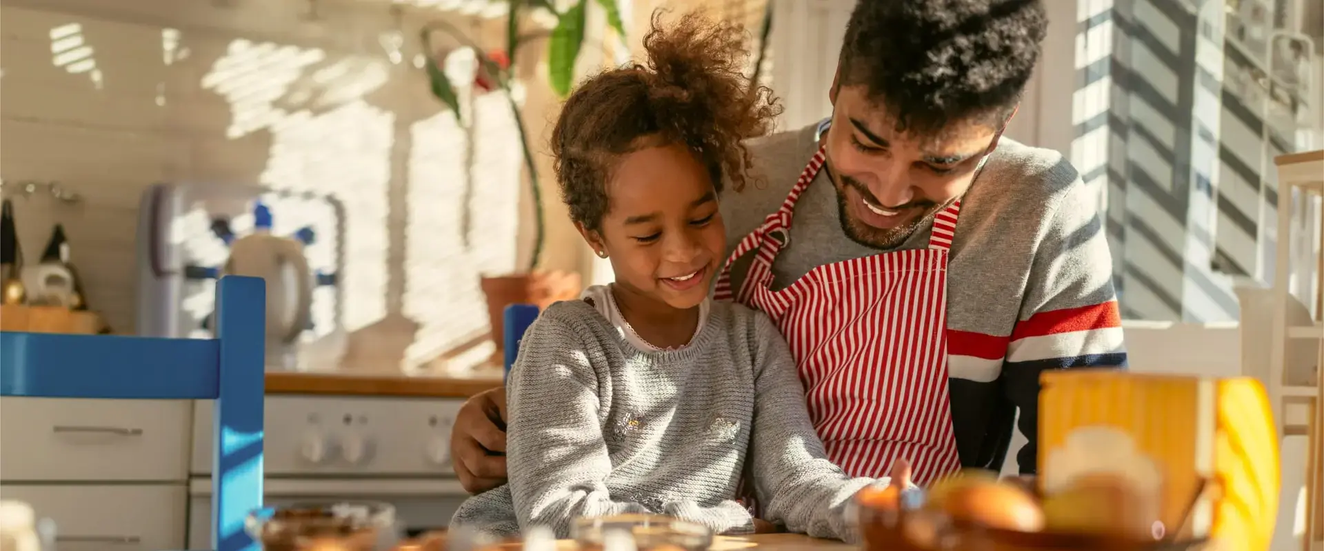 A parent with their child, cooking