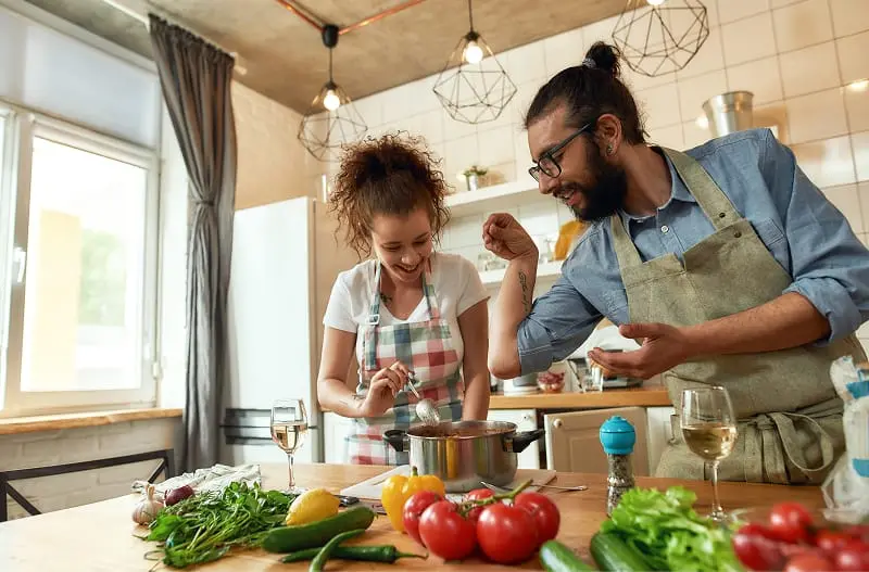 A parent with their child, cooking