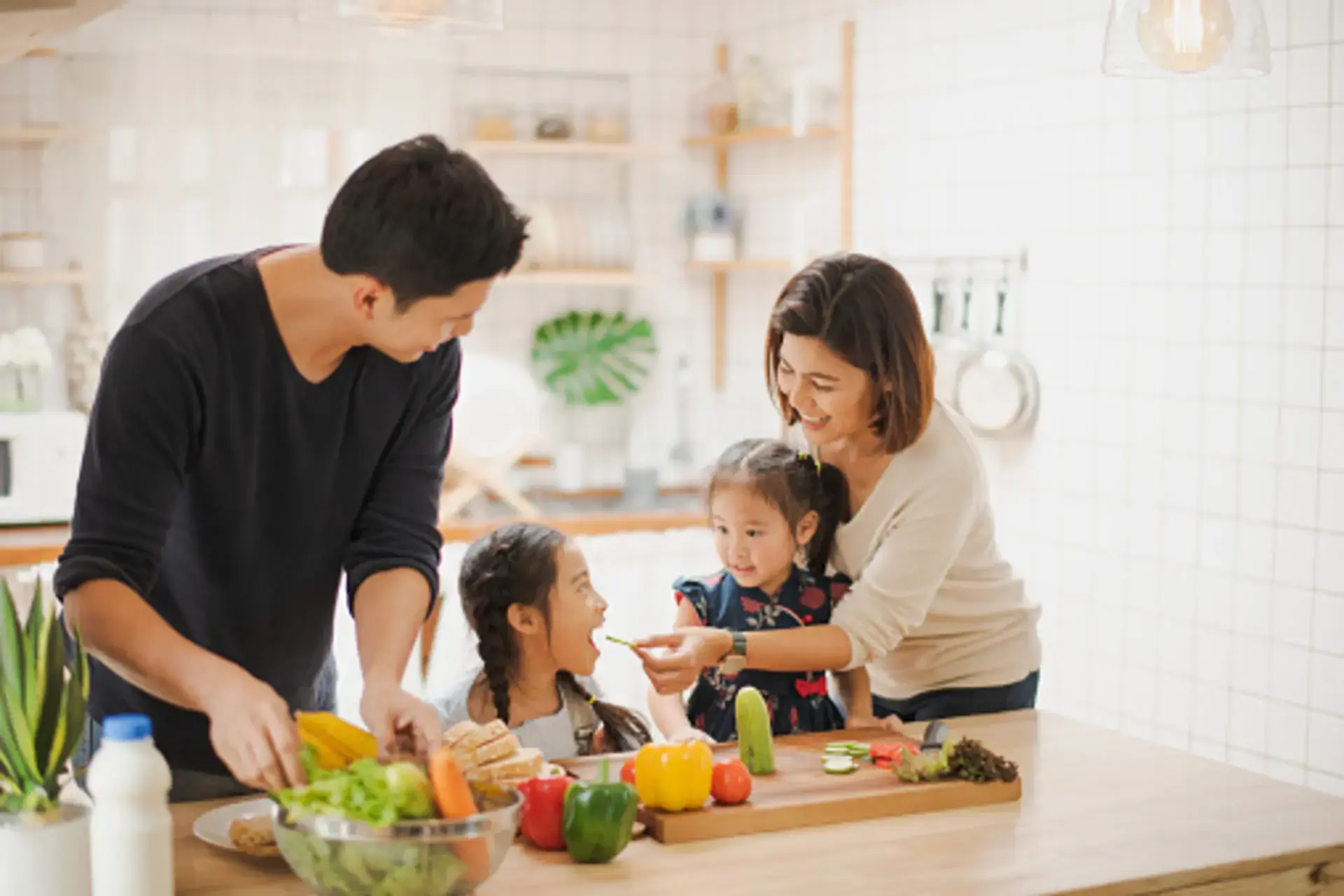 Bố mẹ cùng con thưởng thức bữa ăn với rau củ quả